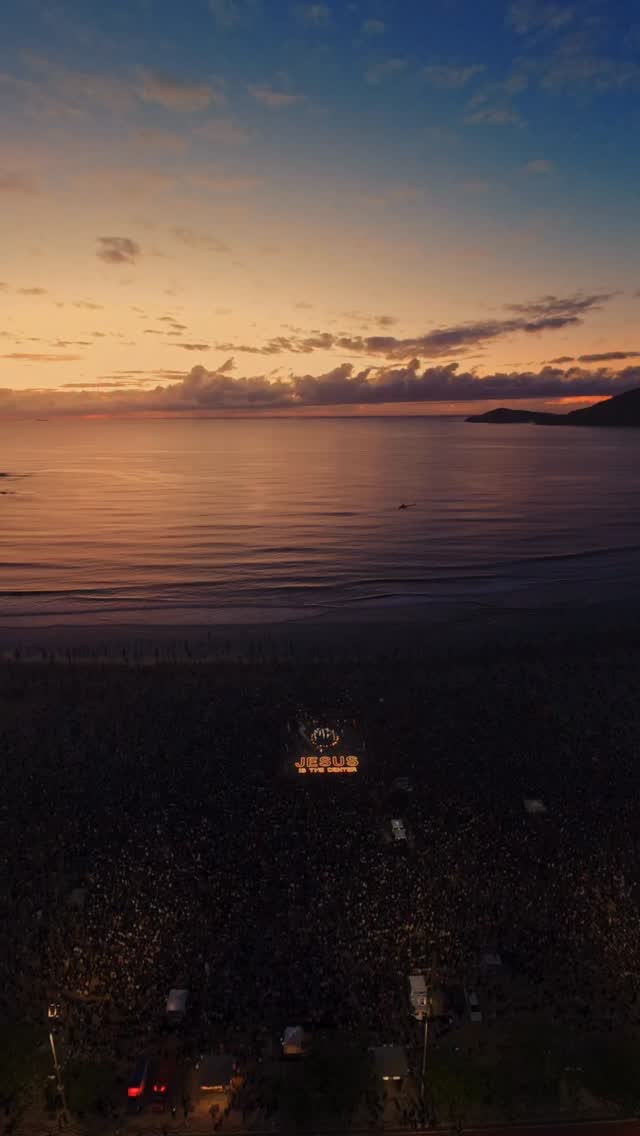 Sol nascendo sobre o mar com multidão